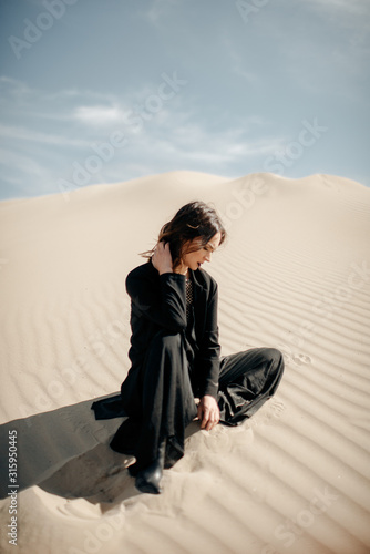 Woman in black dress in desert 
