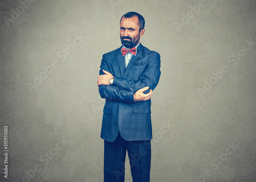 Tableau sur toile man standing looking serious cranky arms crossed