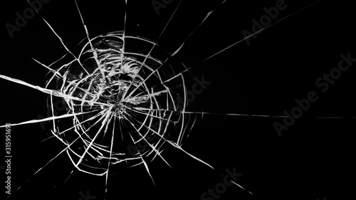 Round white cracks in glass on black background. © maykal