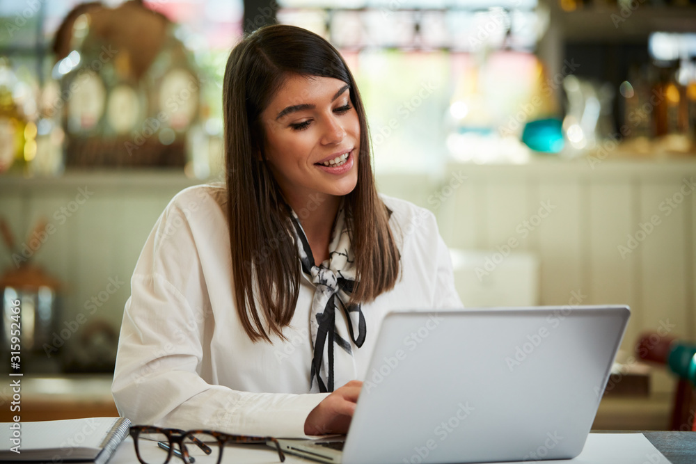 Charming focused caucasian businesswoman with eyeglasses dressed in shirt sitting in cafe and working on important project. Charming focused caucasian businesswoman with eyeglasses dressed in shirt sitting in cafe and working on important project.