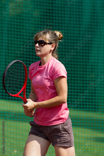 Female tennis player with racket on court © ffolas