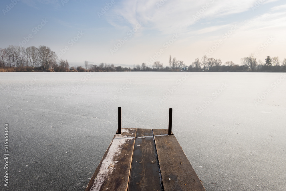 Naklejka premium Pier on frozen lake at winter