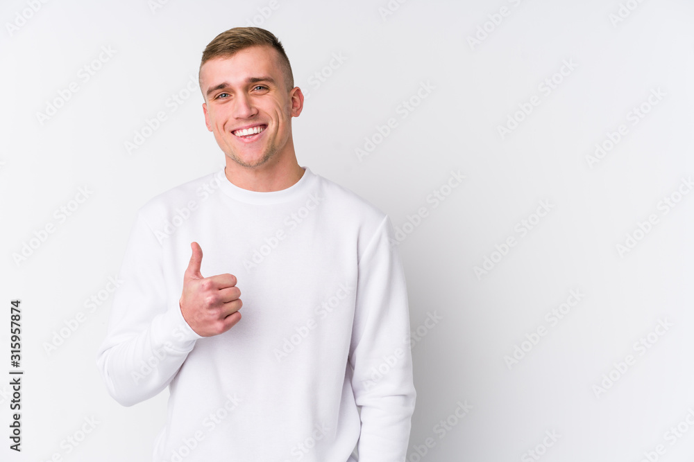 Young caucasian man on white background smiling and raising thumb up Young caucasian man on white background smiling and raising thumb up