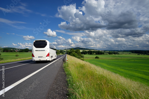 Obraz na płótnie White bus driving on the asphalt road in a rural landscape w salonie
