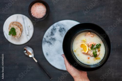 Traditional Finnish salmon soup Lohikeitto with potato, creme and lemon