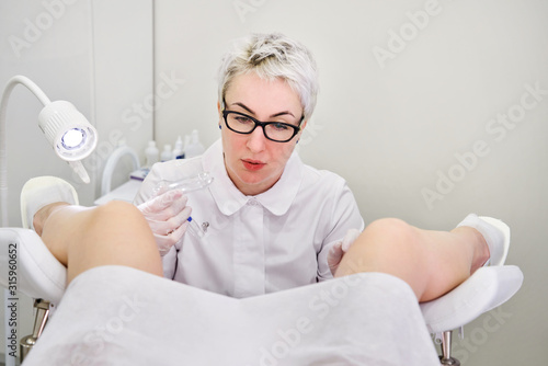 Gynecologist with vaginal speculum in clinic before patient examination photo