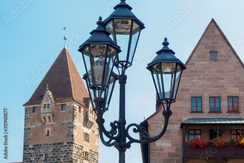 Obraz na płótnie The beautiful lamppost in traditional Bavarian style near the building in the old city in Nuremberg, Bavaria, Germany w salonie