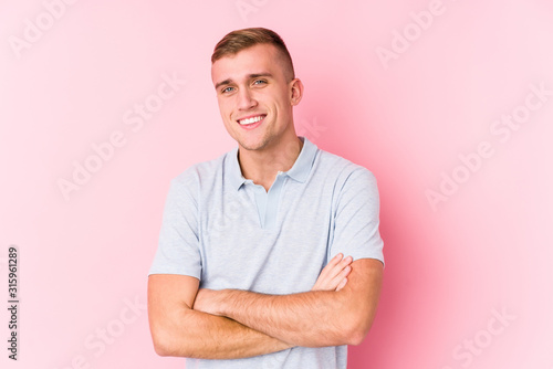 Φωτογραφία Young caucasian man isolated who feels confident, crossing arms with determination