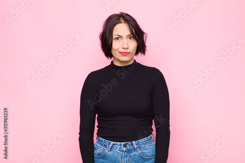 Foto young pretty woman feeling confused and doubtful, wondering or trying to choose