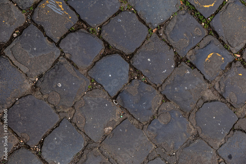 Texture of cobblestone street. Pattern of old avenue. Straight rows of stones.