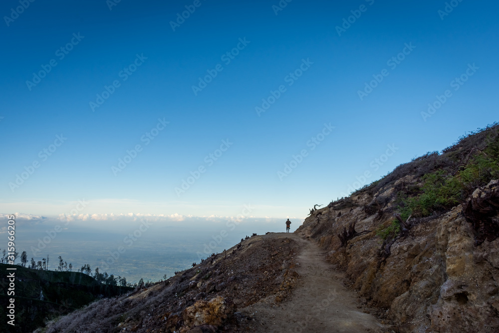 Stunning path with beautiful view on Ijen Crater. Ijen Crater is a volcanic tourism attraction in Indonesia, located on East Java, famously contains the world’s largest acidic volcanic crater lake.