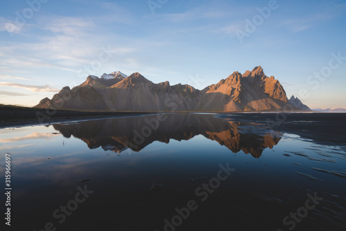 Sunset in Icelandic Mountain Vestrahorn with reflection and clear skies
