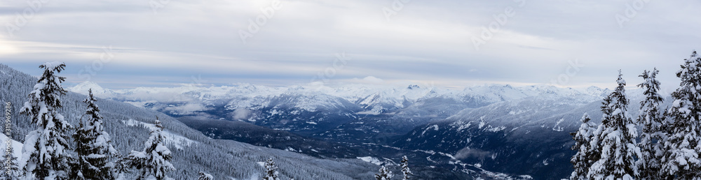Whistler, British Columbia, Canada. Beautiful Panoramic View of the Canadian Snow Covered Mountain Landscape during a cloudy and foggy winter evening.