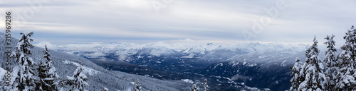 Whistler, British Columbia, Canada. Beautiful Panoramic View of the Canadian Snow Covered Mountain Landscape during a cloudy and foggy winter evening.