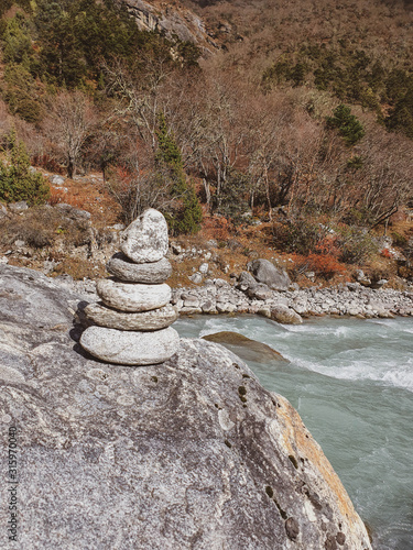 Everest base camp trek itinerary: way from Namche Bazar to Phortse Tanga, Solokhumbu, Nepal. Dudh Koshi river near Phortse Tanga village. Stone pyramide on its bank. photo