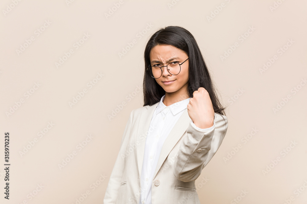 Young business chinese woman showing fist to camera, aggressive facial expression. Young business chinese woman showing fist to camera, aggressive facial expression.