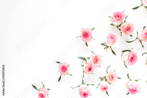Fototapeta Naklejka Na Ścianę i Meble -  Floral composition with pink rose flower buds and leaves pattern on white background. Flatlay, top view.
