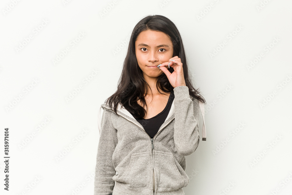 Young fitness chinese woman with fingers on lips keeping a secret. Young fitness chinese woman with fingers on lips keeping a secret.