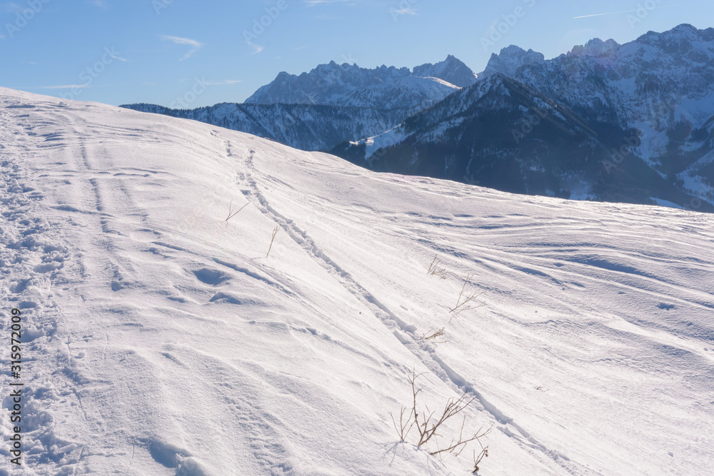 Blick aufs Kaisergebirge im Winter mit Schnee bei blauem Himmel und Sonne