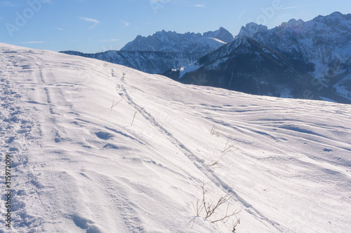 Blick aufs Kaisergebirge im Winter mit Schnee bei blauem Himmel und Sonne