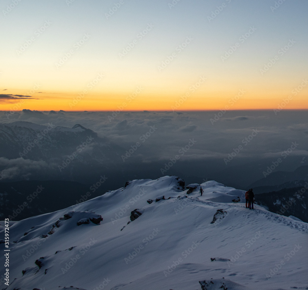 A beautiful view of a sunrise and himalayan mountains from the summit of a himalayan mountain