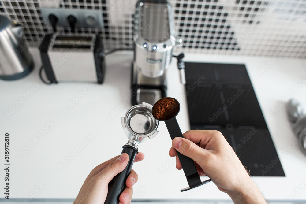 Guy prepare delicious aromatic coffee in a coffee machine. A simple way to make coffee Guy prepare delicious aromatic coffee in a coffee machine. A simple way to make coffee