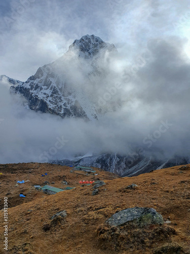 View on Cholatse north face in clouds from Dzongla village. Everest base camp trek: from Dragnag to Dzongla via Cho La pass. Trekking in Solokhumbu, Nepal.