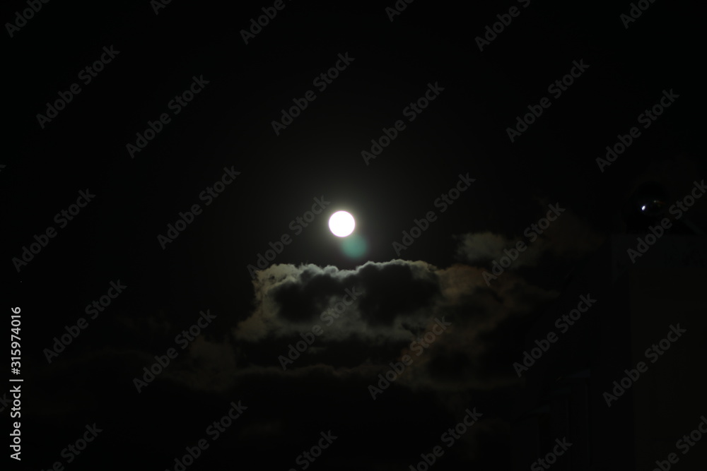 Full moon pictured against cloudy night sky