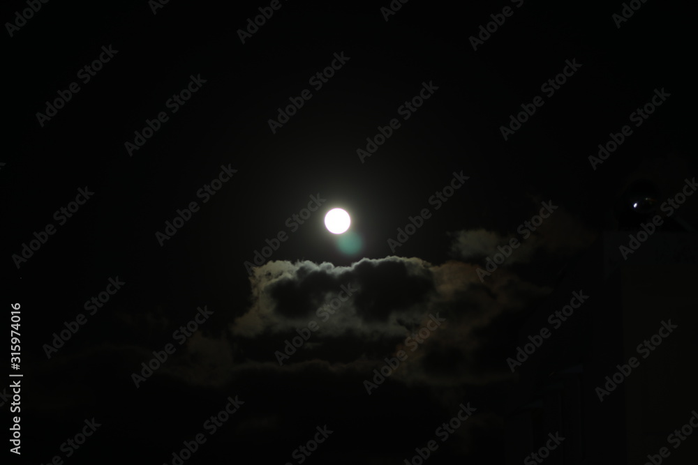 Full moon pictured against cloudy night sky Full moon pictured against cloudy night sky