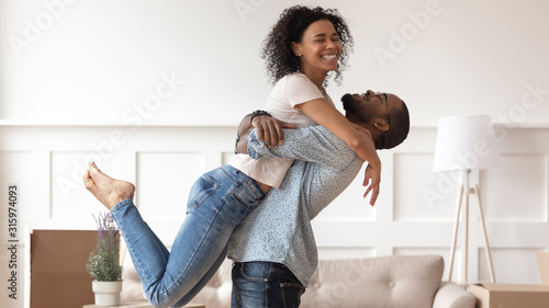 Successful black man raising up happy smiling wife. photo