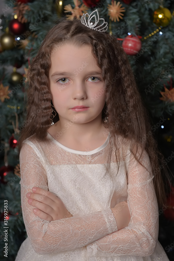 girl in ivory festive dress in christmas with a crown girl in ivory festive dress in christmas with a crown