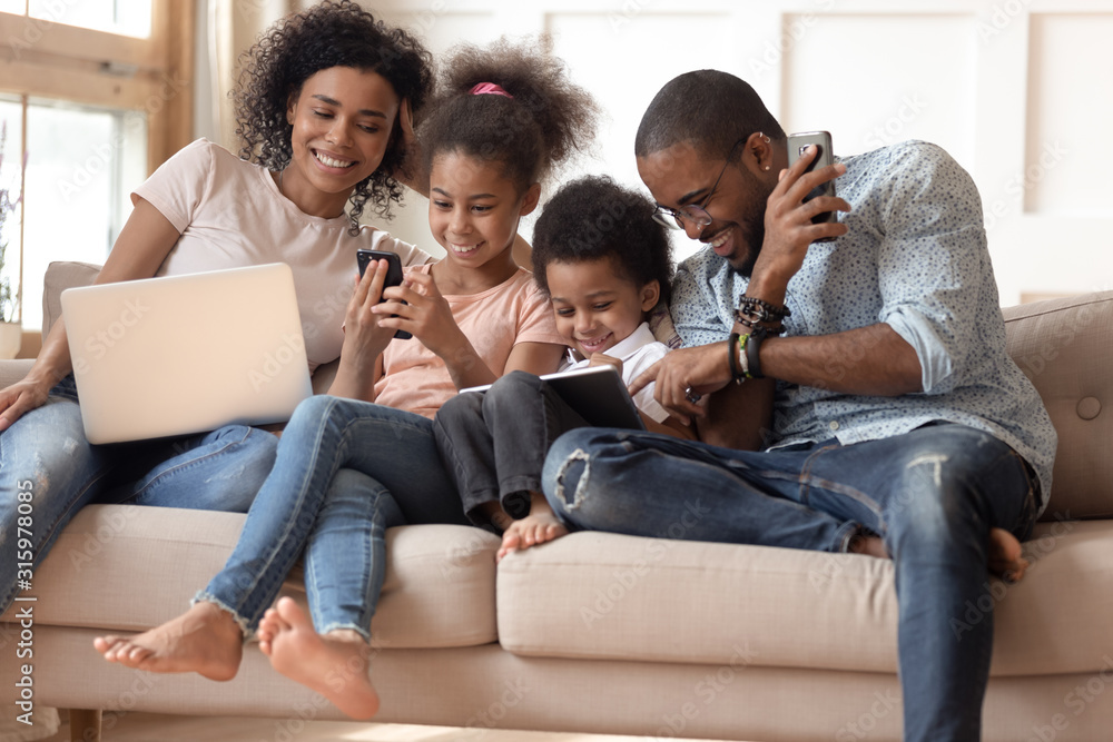 Happy addicted to gadgets black family using different devices. Happy addicted to gadgets black family using different devices.