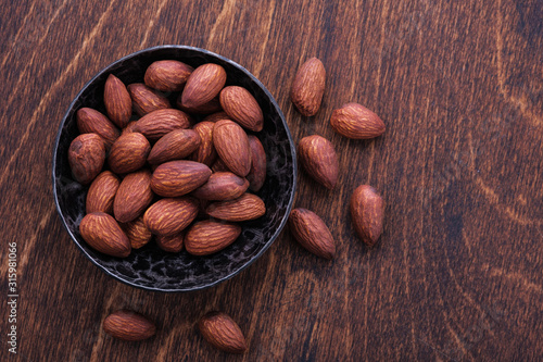almonds in bowl on wooden table