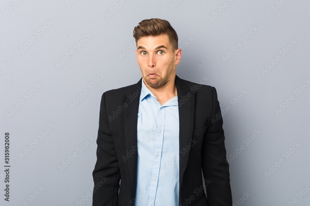 Young handsome caucasian man shrugs shoulders and open eyes confused. Young handsome caucasian man shrugs shoulders and open eyes confused.