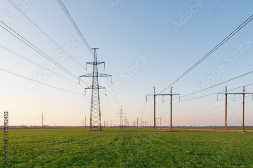 Electrical net of poles on a panorama of blue sky and green meadow © yelantsevv