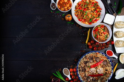 The concept of oriental cuisine. Assorted Uzbek food set, pilaf, samsa, lagman, manta, shurpa Uzbek restaurant concept, Uzbek food. Homemade Uzbek pilaf or plov from lamb served in cast iron cookware photo