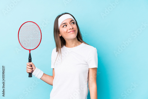 Young caucasic woman playing badminton isolated dreaming of achieving goals and purposes © Asier