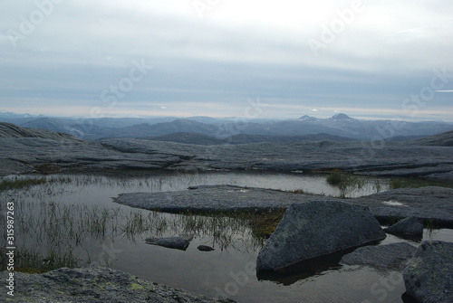  View to mountain lakes and cliffs in the mountain range of Seven Sisters  De syv s  stre  from hiking trail to Tvillingene peak on the island of Alsten  Helgeland  Norway