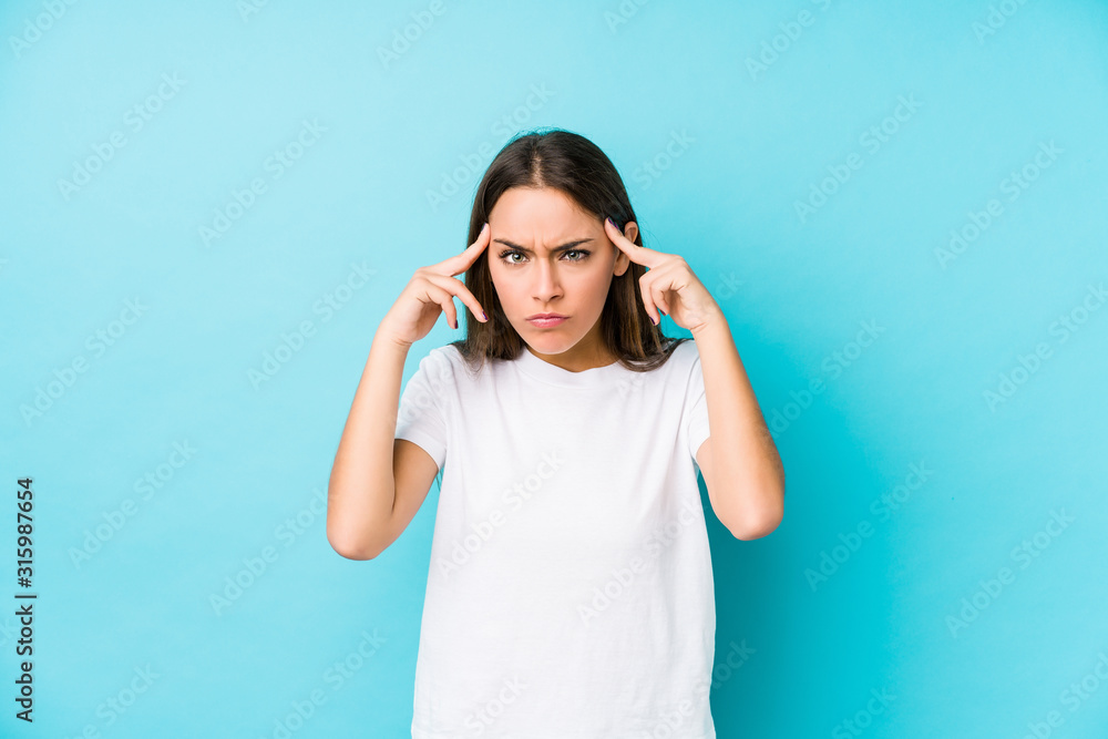 Young caucasian woman isolated focused on a task, keeping forefingers pointing head. Young caucasian woman isolated focused on a task, keeping forefingers pointing head.