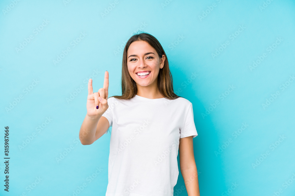 Young caucasian woman isolated showing a horns gesture as a revolution concept. Young caucasian woman isolated showing a horns gesture as a revolution concept.