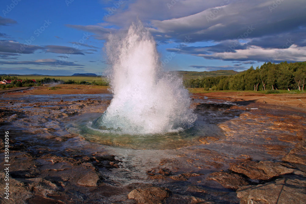 Geysir Strokkur outbreak with blue sky