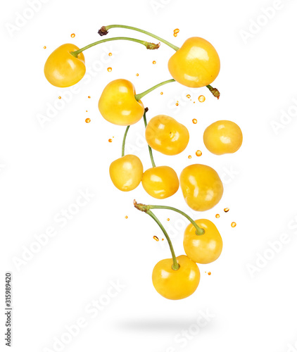 Yellow cherries in the air isolated on white background