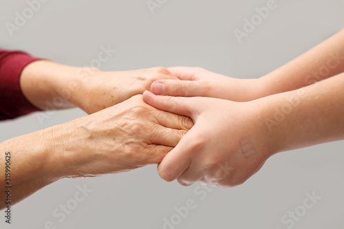 Senior and child's hands. Care and safety of generations
