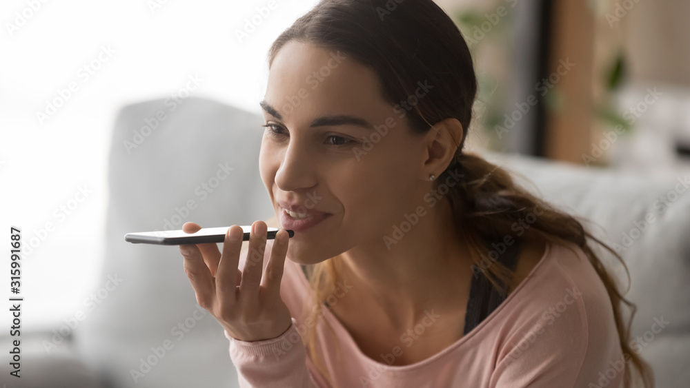 Millennial woman holding mobile phone, recording audio message. Millennial woman holding mobile phone, recording audio message.