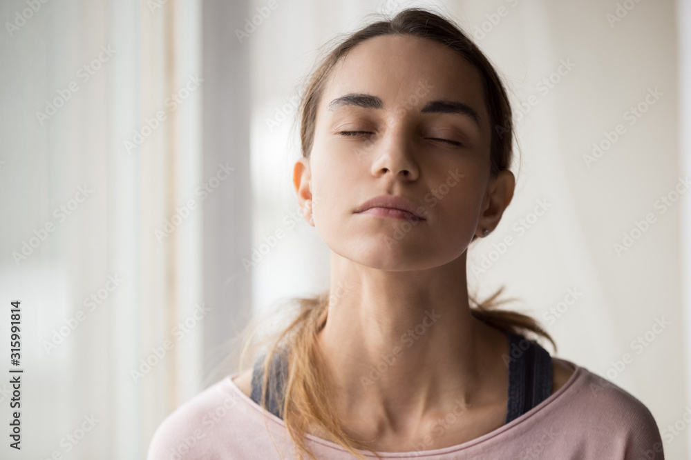 Calm young woman sitting with closed eyes. Calm young woman sitting with closed eyes.