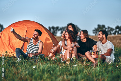 Group of best friends taking a selfie while camping together. photo