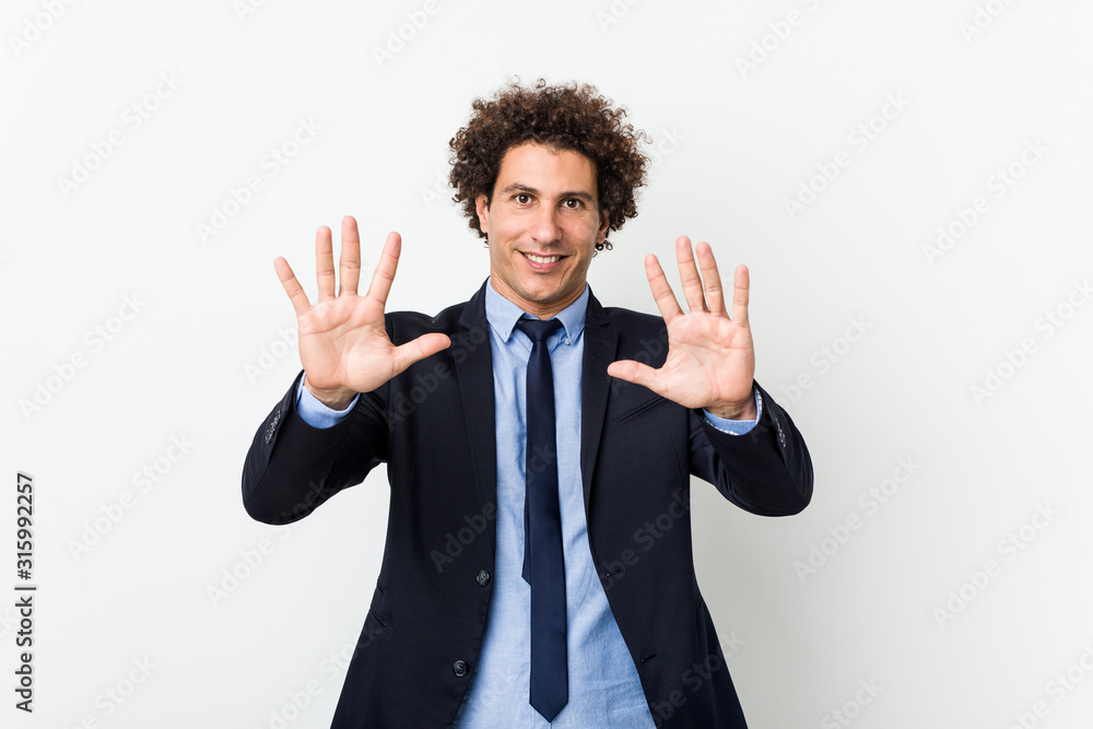 Young business curly man against white background showing number ten with hands. Young business curly man against white background showing number ten with hands.
