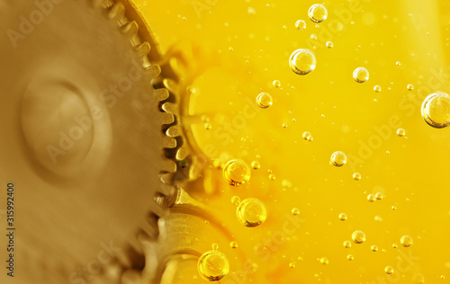 Metal gear in oil. Car service concept. Oil change in mechanisms, engines, motors.