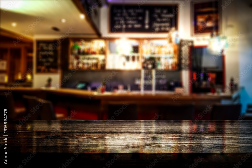 Table background of free space for your decoration and blurred background of bar 