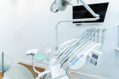 Modern dental practice. Dental chair and other accessories used by dentists in blue, medic light. Medical concept.